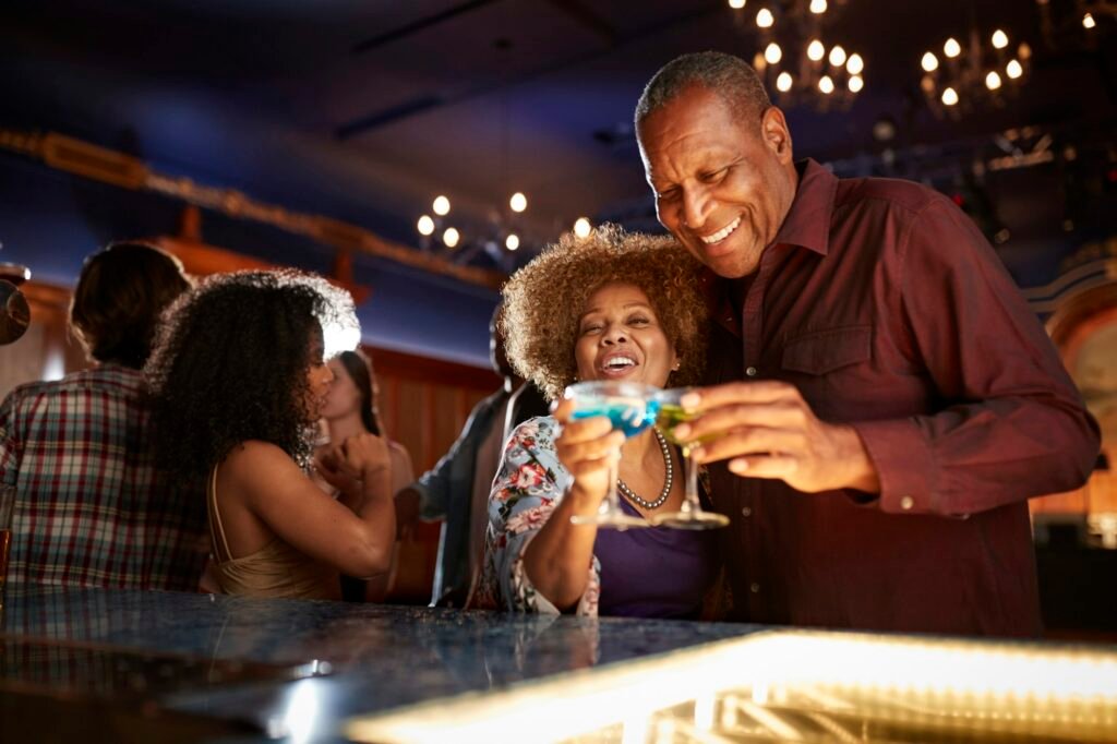 Portrait Of Senior Couple Drinking And Dancing In Bar Together